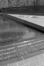 Korean War - The pool of remberance - Water glides over black granite, seemingly motionless until it gently falls over the edge of the circular base. The tip of the triangular area on which the 19 soldiers and graphite wall stand, slices into the center, providing a foundation for a flag. Circling the pool, benches and linden trees provide an area for rest and reflection. In the background, flowering Rose of Sharon shrubs, the national flower of South Korea, will eventually form a hedge against the outside. A wall bearing the inscription "Freedom is not free" stands separate from the wall of faces. But what is the cost of freedom? As an answer, the Allied toll in the Korean War, 1950-1953, is etched on the lip of the pool: