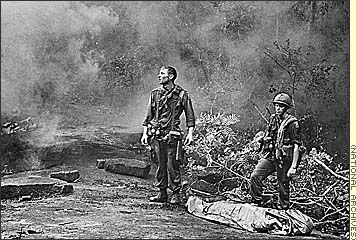 Vietnam War - Combat Chronicles, Photographs of the Vietnam War Part 1 - After the battle, In Long Khanh province, Vietnam, R. Richter of the 4th Battalion, 503rd Infantry, 173rd Airborne Brigade, left, and Sgt. Daniel E. Spencer await the helicopter that will airlift their dead comrade, 1966